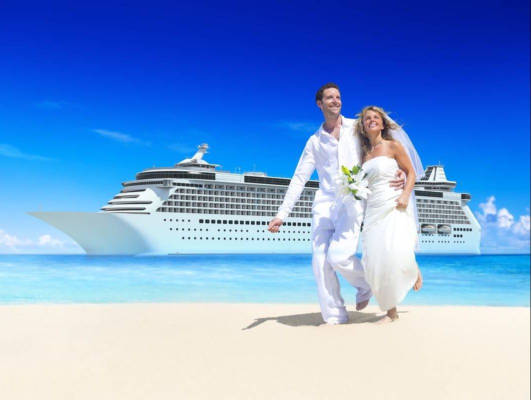 Newlyweds in front of cruise ship a beach shore